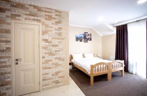 1 dormitorio con cama y pared de ladrillo en Готель River House en Umanʼ