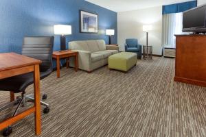 a living room with a couch chair and a tv at Drury Inn & Suites St. Louis Fenton in Fenton