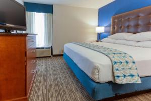 a hotel room with a bed and a flat screen tv at Drury Inn & Suites St. Louis Fenton in Fenton