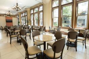 a waiting room with tables and chairs and windows at Drury Inn & Suites San Antonio Riverwalk in San Antonio