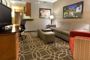 a living room with a couch and a flat screen tv at Drury Inn & Suites San Antonio Riverwalk in San Antonio