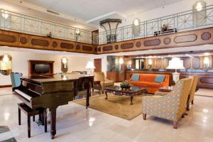 een woonkamer met een piano en een bank bij Pear Tree Inn St Louis Convention Center in Saint Louis