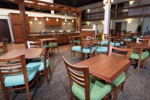 une salle à manger avec des tables et des chaises en bois dans l'établissement Pear Tree Inn St Louis Convention Center, à Saint-Louis