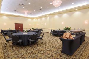 a banquet hall with black tables and chairs at Pear Tree Inn St Louis Convention Center in Saint Louis