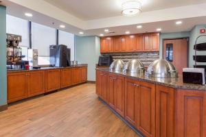 a large kitchen with wooden cabinets and stainless steel pots at Drury Inn & Suites Birmingham Grandview in Birmingham