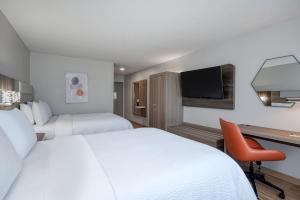 Habitación de hotel con 2 camas, escritorio y TV. en Holiday Inn Express Hotel & Suites Columbia-I-20 at Clemson Road, an IHG Hotel en Columbia