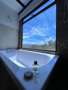 uma casa de banho com uma grande janela e um lavatório branco em Villa Skape - Finca Villa Carolina em Villa de Leyva
