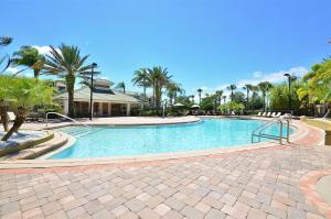 a large swimming pool with palm trees in a resort at Vista Cay Getaway Luxury Condo by Universal Orlando Rental in Orlando