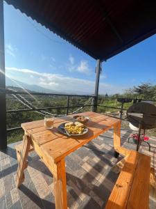 ein Holztisch mit einem Teller mit Essen darauf in der Unterkunft Villa Skape - Finca Villa Carolina in Villa de Leyva