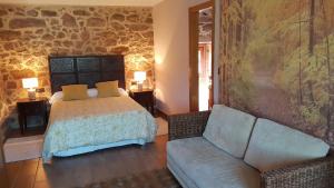 - une chambre avec un lit et un canapé dans l'établissement Bubela finca, à Pontevedra