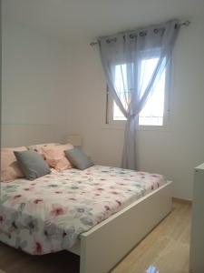 1 dormitorio con 1 cama y ventana en Casa en Jerez con patio cerca de la playa y de la sierra, en Jerez de la Frontera