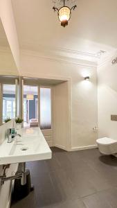 La salle de bains blanche est pourvue d'un lavabo et de toilettes. dans l'établissement VAGO Alcântara Suites, à Lisbonne
