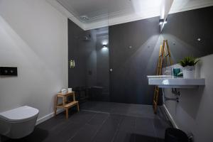 a bathroom with a white toilet and a sink at VAGO Alcântara Suites in Lisbon