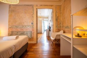 a bedroom with a bed and a desk in a room at VAGO Alcântara Suites in Lisbon