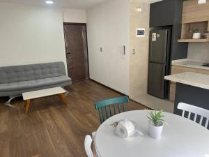 a kitchen and a living room with a table and a couch at Excelente ubicación y cómoda estadía in La Paz