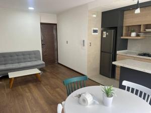 a living room with a white table and a kitchen at Excelente ubicación y cómoda estadía in La Paz