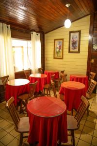 um restaurante com mesas e cadeiras com mesas vermelhas em Pousada do Romildo em Fernando de Noronha