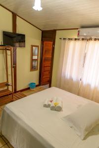 a bedroom with a bed with two towels on it at Pousada do Romildo in Fernando de Noronha