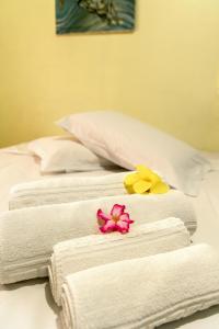 tres toallas y flores sentadas encima de una cama en Pousada do Romildo, en Fernando de Noronha 8 fotos más