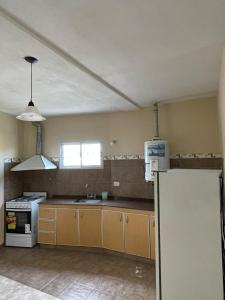 an empty kitchen with a sink and a refrigerator at Departamento Alta Gracia in Alta Gracia
