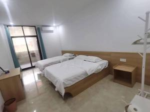 a bedroom with two beds and a window at Olioinn B&B in Wenchang