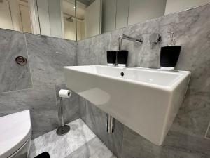 een badkamer met een witte wastafel en een toilet bij Chic Covent Garden Apartment By Sloanes Group in Londen