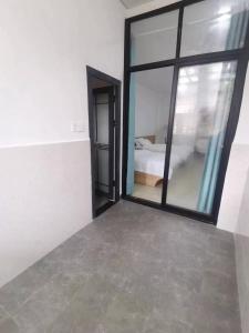 um quarto com uma grande janela e um quarto em Olioinn B&B em Wenchang