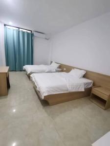 a bedroom with three beds and a table and atained at Olioinn B&B in Wenchang
