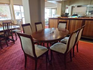 a wooden table and chairs in a restaurant at Myrtleford Hotel in Myrtleford