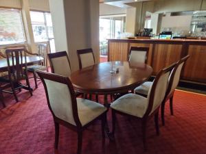 麦提福特Myrtleford Hotel的餐厅里的一张木桌和椅子
