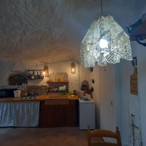 una cocina con una lámpara de araña colgando del techo en La grotta, en Fabrica di Roma