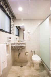 a bathroom with a toilet and a sink at Hotel Diligencias in Mexico City