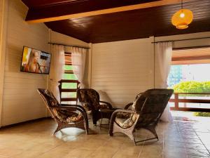 una veranda con sedie in vimini e tavolo di Pousada Jardins a Santarém