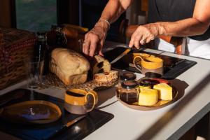 a person cutting a loaf of bread on a table at Pousada Refúgio Araçá in Morro Redondo
