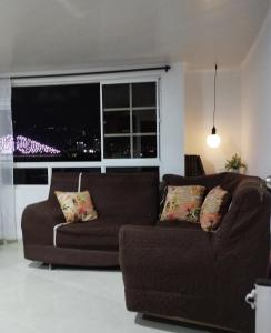 a living room with a couch and a large window at Apartamento con vista a la ciudad en barrio campo hermoso 301 in Bucaramanga +9 photos