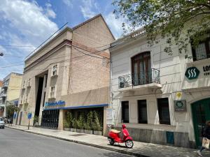 una moto roja estacionada frente a un edificio en Ruffus´s Apple Rosario, en Rosario