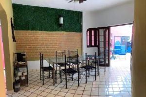 Un comedor con una mesa y sillas y una pared de ladrillos. en Villa Oasis-Solo Traveller Studio Room, en Puerto Vallarta