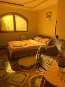 1 dormitorio con 2 camas, sofá y ventana en Nautilus, en Uzhhorod