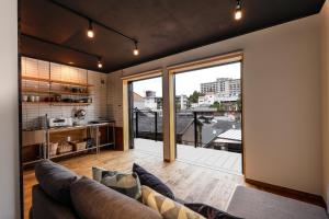 a living room with a couch and a large window at 貸別荘 楓-Fū- 有馬 in Arima