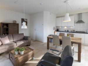 ein Wohnzimmer mit einem Sofa und einem Tisch in der Unterkunft Zeebaars in Egmond aan Zee