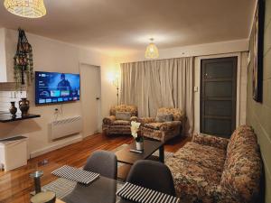 uma sala de estar com um sofá e cadeiras e uma televisão em CQN's em Wellington