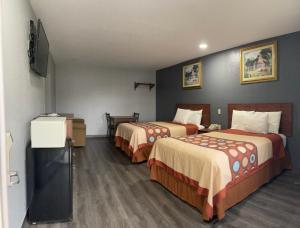 Habitación de hotel con 2 camas y TV de pantalla plana. en Budget Inn Buffalo en Buffalo