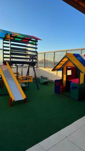 einen Spielplatz mit Rutsche und Spielhaus in der Unterkunft Apartamento perto da praia em Itapoã in Vila Velha