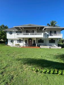 una gran casa blanca con un gran patio en Jamaica Villa By The Sea, en Saint Mary