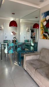 ein Wohnzimmer mit einem Tisch und einem Sofa in der Unterkunft Apartamento perto da praia em Itapoã in Vila Velha