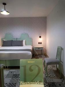 um quarto com uma cama grande e uma cadeira em Añoranza Hotel Boutique em Ciudad Hidalgo