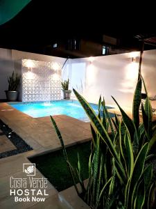 a swimming pool in a house with plants and lights at Costa Verde Hostal in Manta