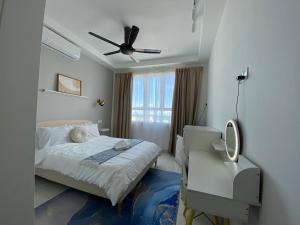 a bedroom with a bed and a desk and a ceiling fan at The Cotton Bleu Homestay in Kuala Terengganu +28 photos