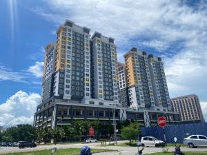 duży wysoki budynek z samochodami zaparkowanymi przed nim w obiekcie The Cotton Bleu Homestay w mieście Kuala Terengganu