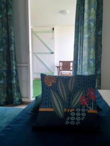 una camera con letto, piumone blu e sedia di Appartement tout confort ! Au pied de la plage ! a Sainte-Anne